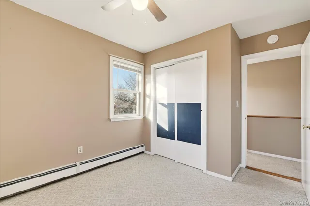 a view of an empty room with closet and a window