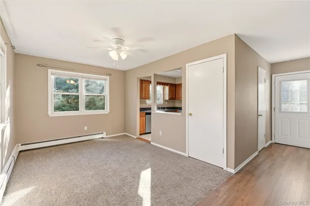 an empty room with windows and ceiling fan