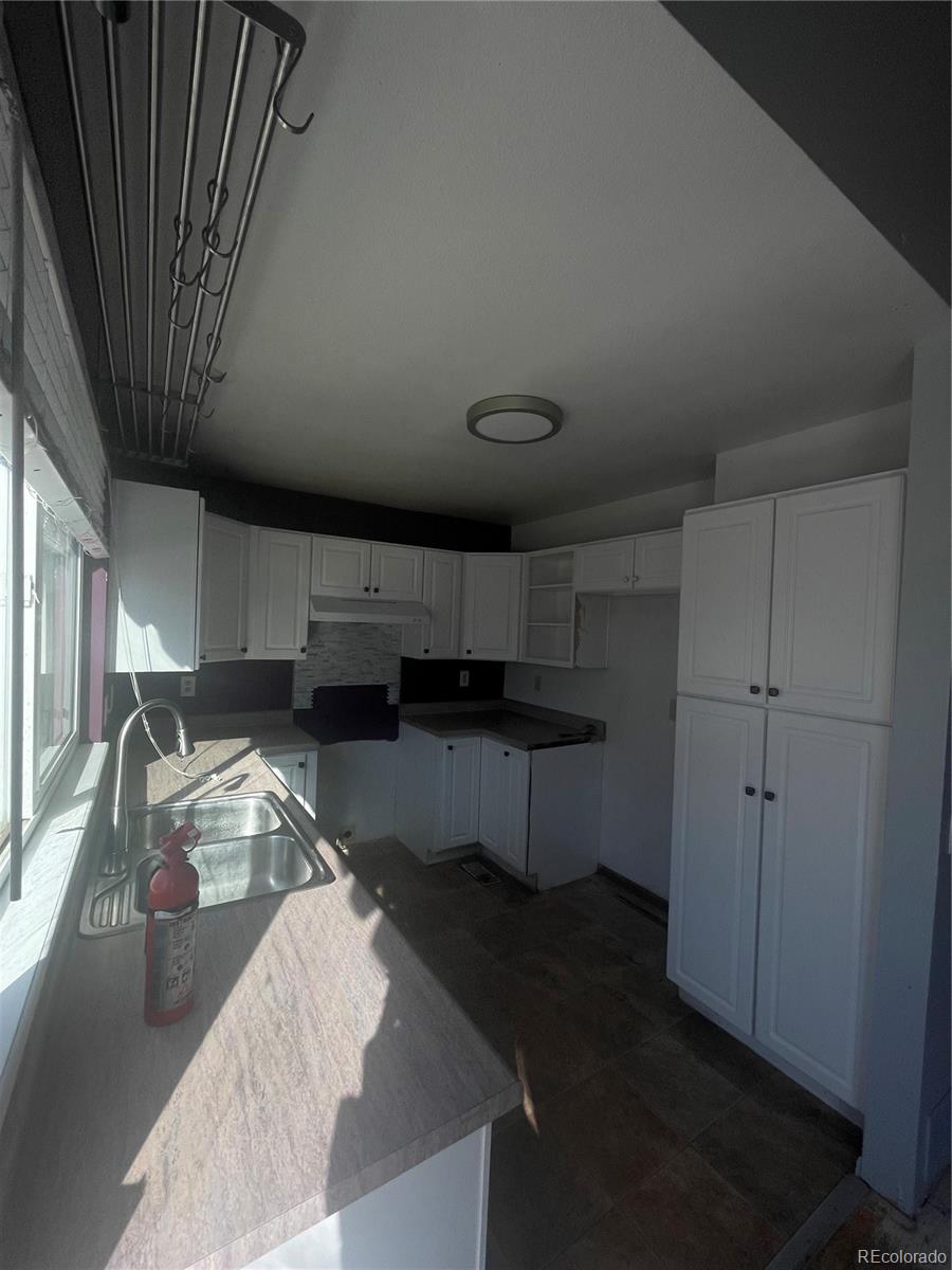 3817 South Ceylon Way Aurora, CO 80013 - Photo 5 of 18 a kitchen with a sink dishwasher a stove and a refrigerator with wooden cabinets