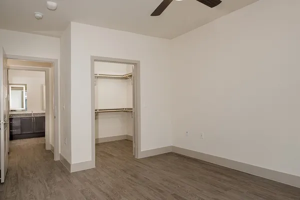 a view of an empty room with closet and a window