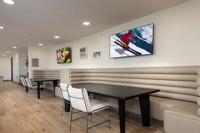 a living room with couches and a painting on the wall