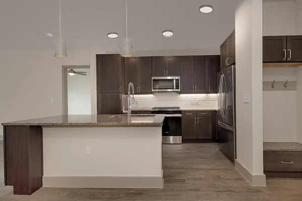 a large kitchen with cabinets wooden floor and stainless steel appliances