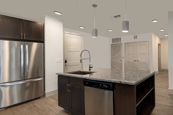 a kitchen with stainless steel appliances granite countertop a sink a refrigerator and a granite counter tops