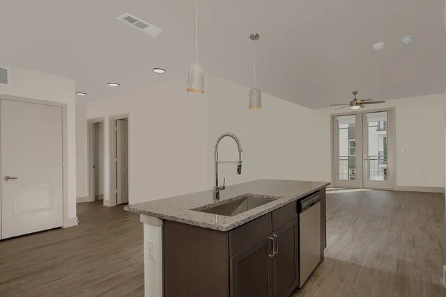 a view of a kitchen island with sink and wooden floor