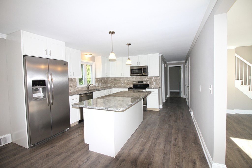 68 Mill Road East Longmeadow, MA 01028 - Photo 2 of 12 a kitchen with stainless steel appliances a refrigerator a stove a sink and white cabinets with wooden floor
