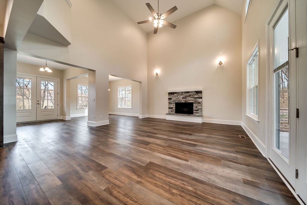 685 Wallace Road Gallatin, TN 37066 - Photo 36 of 64 an empty room with wooden floor a ceiling fan a fireplace and windows