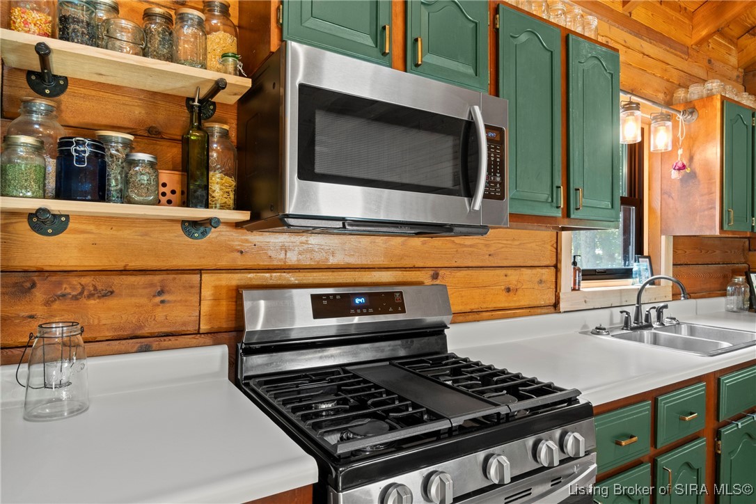 3895 Utz Road Northeast Georgetown, IN 47122 - Photo 12 of 70 Close-up of kitchen stove, microwave, and open shelving with rustic jar storage.