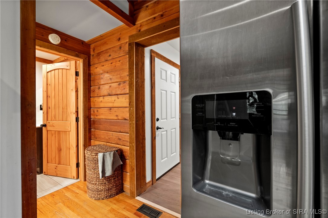 3895 Utz Road Northeast Georgetown, IN 47122 - Photo 13 of 70 Hallway view from kitchen area toward bathroom and back entry, with stainless steel refrigerator in foreground.