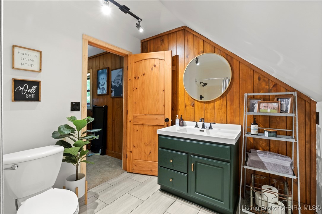 3895 Utz Road Northeast Georgetown, IN 47122 - Photo 27 of 70 Upstairs Bathroom Vanity – Features a deep green vanity with modern black fixtures, wood accent wall, and open shelving for storage.