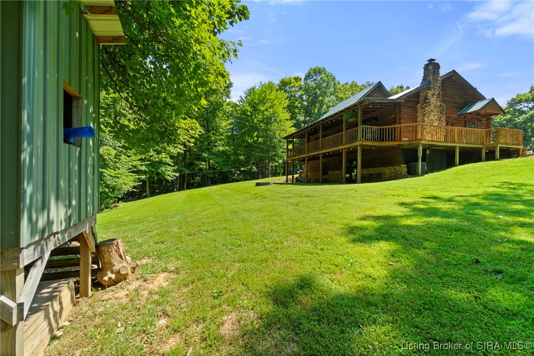 3895 Utz Road Northeast Georgetown, IN 47122 - Photo 3 of 70 Playhouse and Rear Lawn View – Elevated green playhouse and spacious backyard with covered deck.