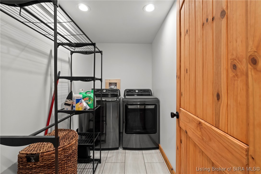 3895 Utz Road Northeast Georgetown, IN 47122 - Photo 38 of 70 Laundry Room – Equipped with a modern washer and dryer, open shelving, and tile flooring for easy maintenance.