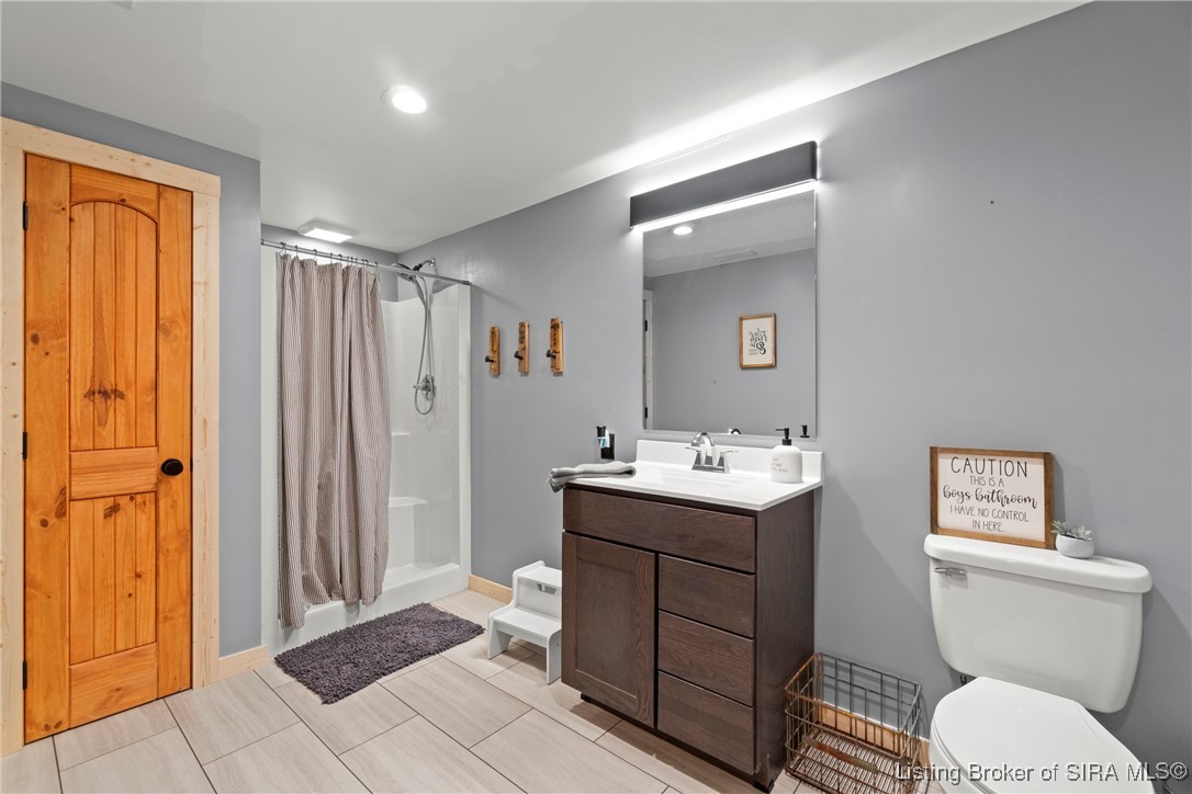 3895 Utz Road Northeast Georgetown, IN 47122 - Photo 39 of 70 Lower-Level Full Bathroom – Features a step-in shower, single vanity, and neutral finishes with natural wood door accents.