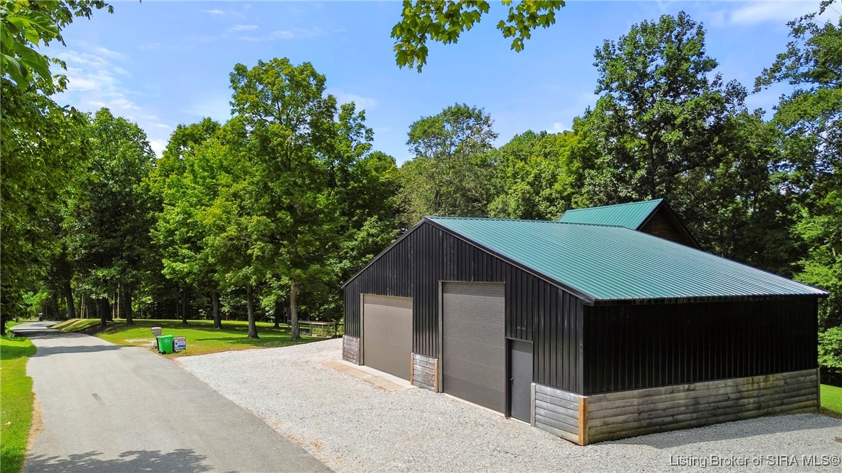3895 Utz Road Northeast Georgetown, IN 47122 - Photo 40 of 70 Detached Garage/Workshop – Expansive black metal building with dual oversized garage doors and gravel drive.