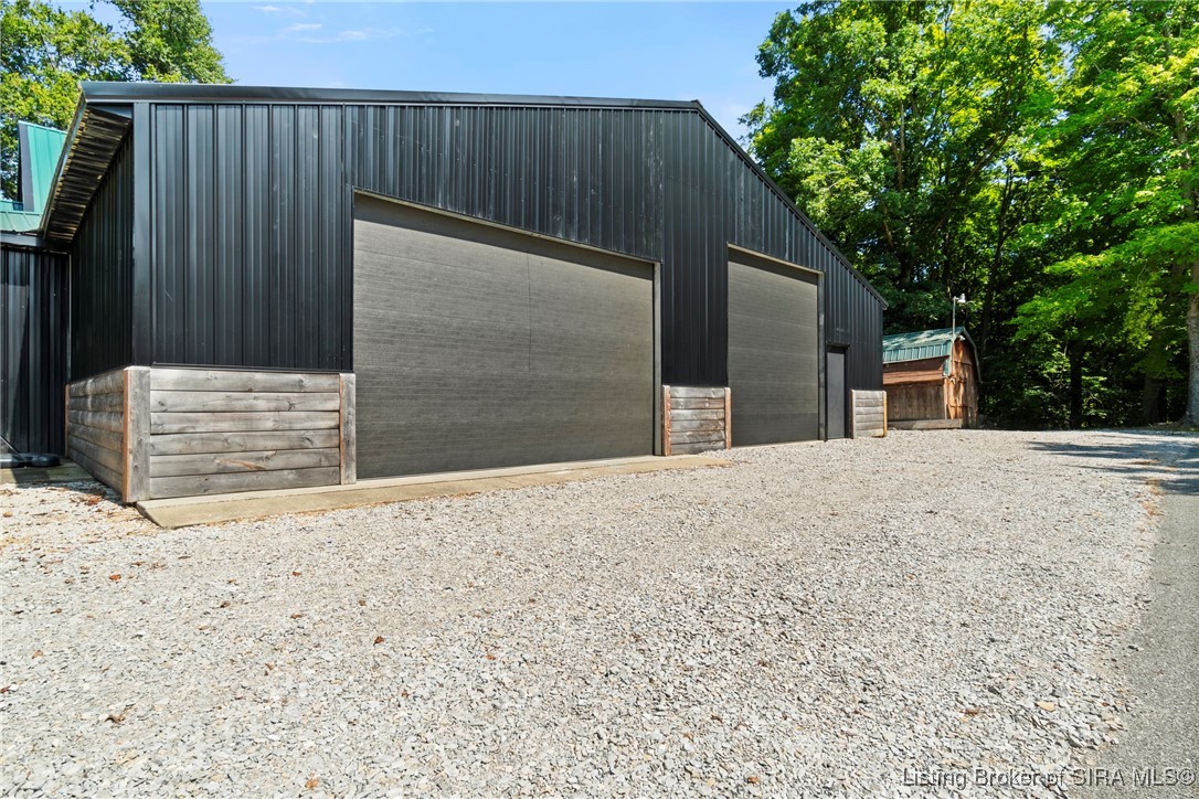 3895 Utz Road Northeast Georgetown, IN 47122 - Photo 5 of 70 Detached Workshop Front View – Large black metal structure with dual oversized garage doors and gravel approach.