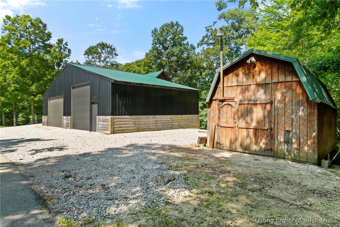 3895 Utz Road Northeast Georgetown, IN 47122 - Photo 54 of 70 Workshop and Shed – Spacious workshop alongside a rustic wood storage shed with green roof.