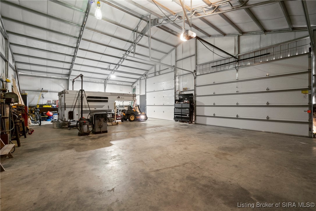 3895 Utz Road Northeast Georgetown, IN 47122 - Photo 6 of 70 Expansive detached workshop interior with tall ceilings, multiple oversized garage doors, and abundant space for vehicles, tools, and projects.