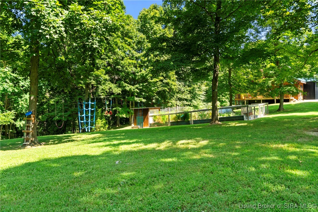 3895 Utz Road Northeast Georgetown, IN 47122 - Photo 61 of 70 Backyard Play Area – Rope swings, climbing nets, and play features in a shaded, grassy backyard.