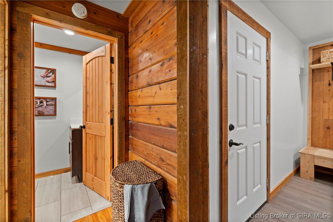 3895 Utz Road Northeast Georgetown, IN 47122 - Photo 62 of 70 Entryway hall leading to half-bath and back door, with wicker laundry basket and wooden trim.