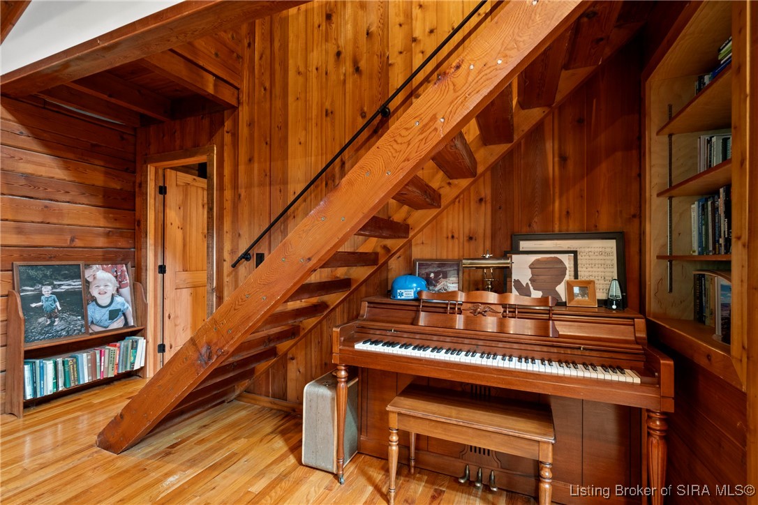 3895 Utz Road Northeast Georgetown, IN 47122 - Photo 9 of 70 Upright piano nestled beneath the staircase with built-in bookshelves and family photos.