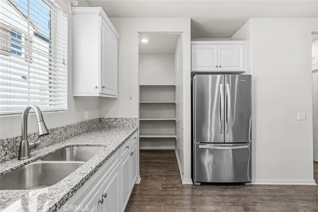 a kitchen with a refrigerator sink and cabinets
