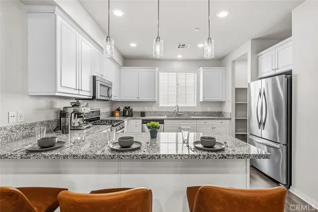 a kitchen with stainless steel appliances granite countertop a sink a stove and a refrigerator