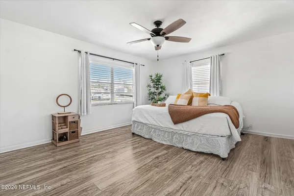 a bedroom with a bed and wooden floor