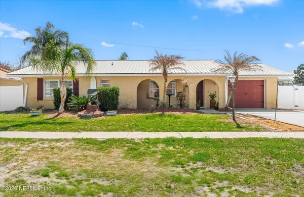 a front view of a house with a garden and plants