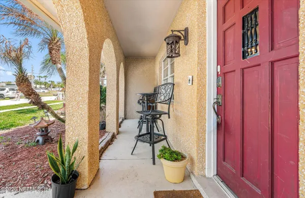a living room with furniture floor to ceiling window and potted plant