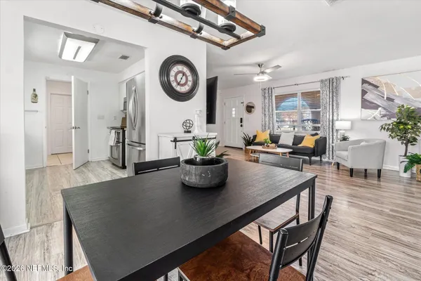 a dining room filled chandelier and kitchen view