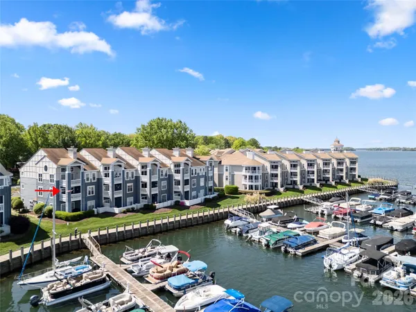 an aerial view of lake and residential houses with outdoor space