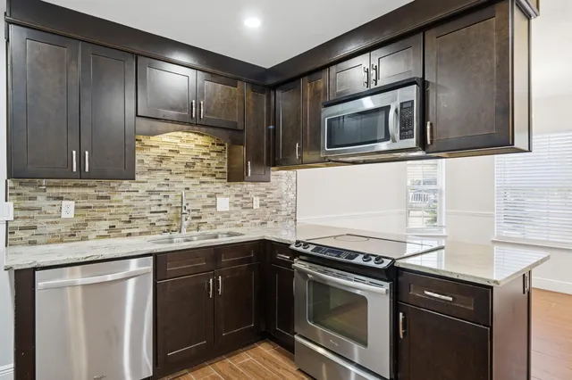 a kitchen with stainless steel appliances granite countertop a sink and a microwave