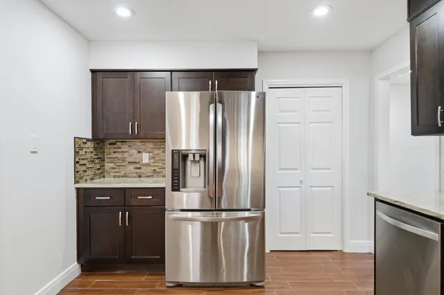 a kitchen with stainless steel appliances granite countertop a refrigerator and a stove top oven