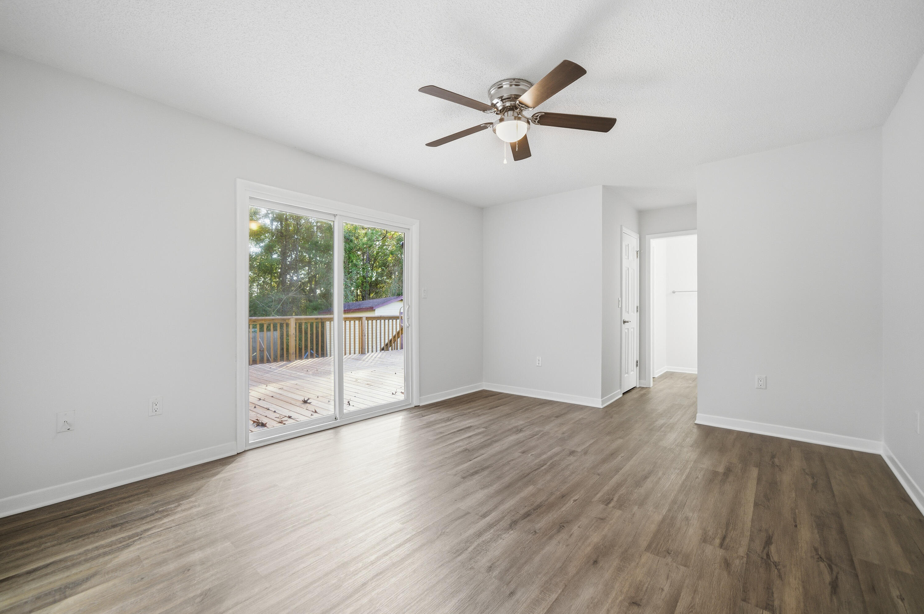 411 Ashley Drive Crestview, FL 32536 - Photo 16 of 44 an empty room with wooden floor and windows