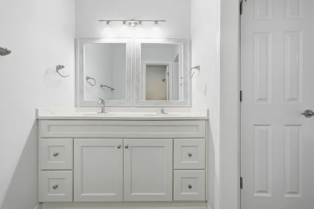 a bathroom with a sink vanity and mirror