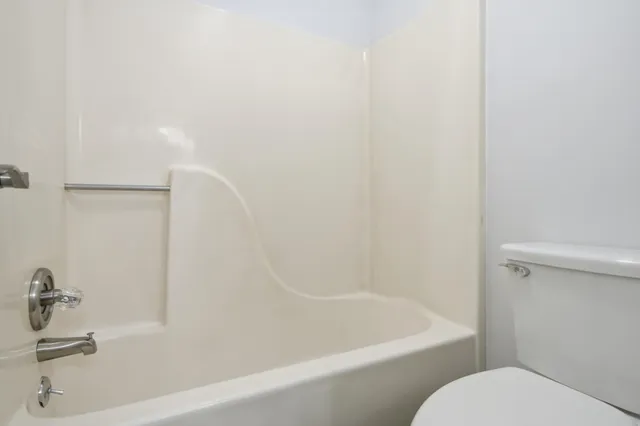 a white bath tub sitting next to a white toilet