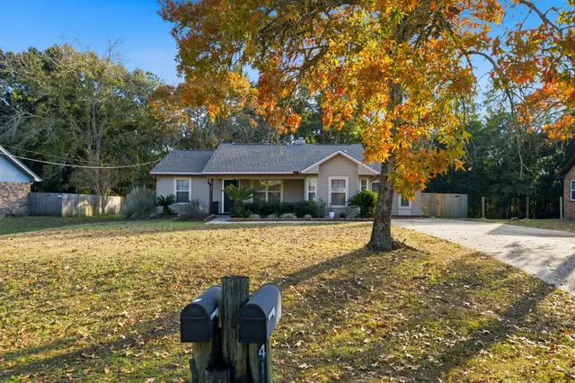 a front view of house with yard and trees in the background