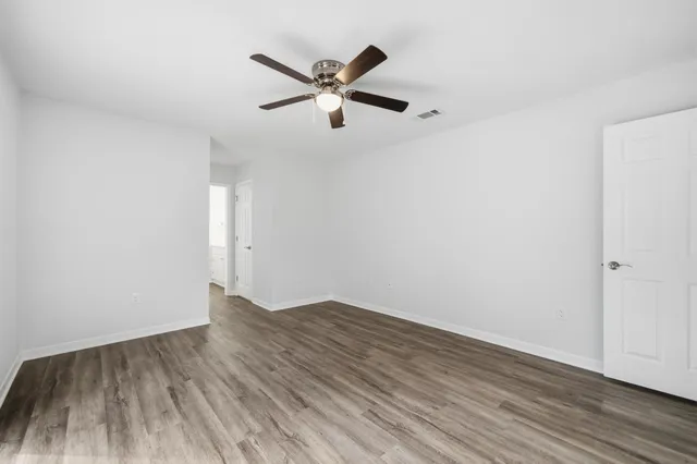 a view of empty room with wooden floor