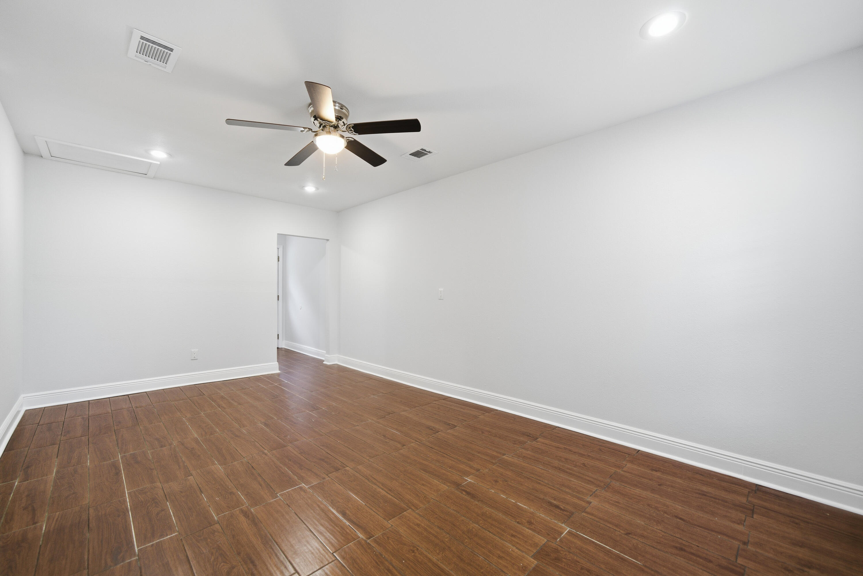 411 Ashley Drive Crestview, FL 32536 - Photo 32 of 44 an empty room with wooden floor ceiling fan and ceiling fan