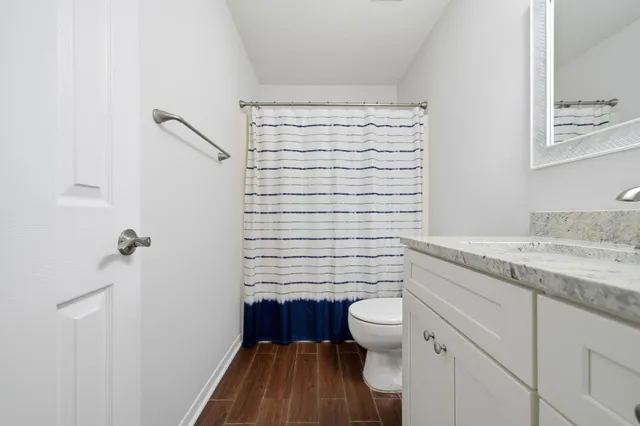 a bathroom with a granite countertop toilet a sink and a shower