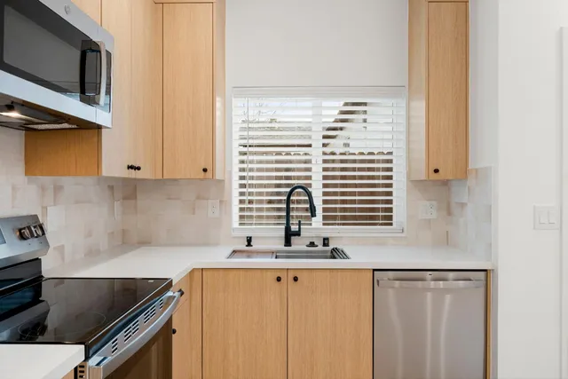 a view of a room with a ceiling fan and wooden floor