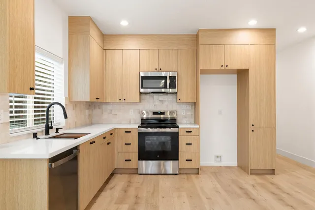 a kitchen with stainless steel appliances granite countertop a stove a sink and a microwave