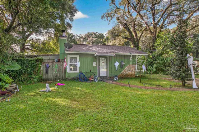 a view of a house with backyard and sitting area