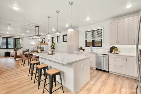 a kitchen with white cabinets and sink