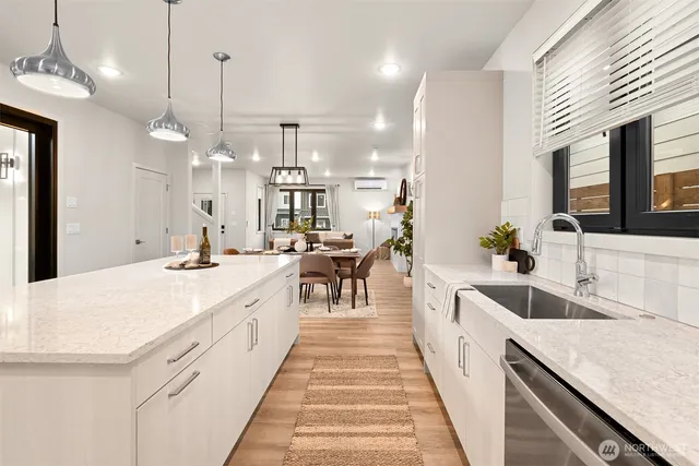 a large kitchen with kitchen island a large counter top a sink a center island and living room view