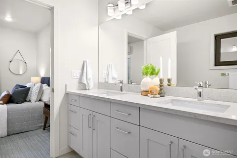 a en suite bathroom with a double vanity sink and a mirror