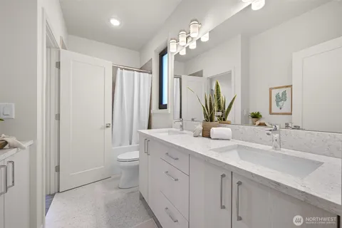 a bathroom with a double vanity sink and a mirror