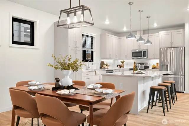 a dining room with wooden floor a chandelier a wooden table and chairs
