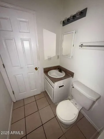 a white toilet sitting next to a bathroom sink and vanity
