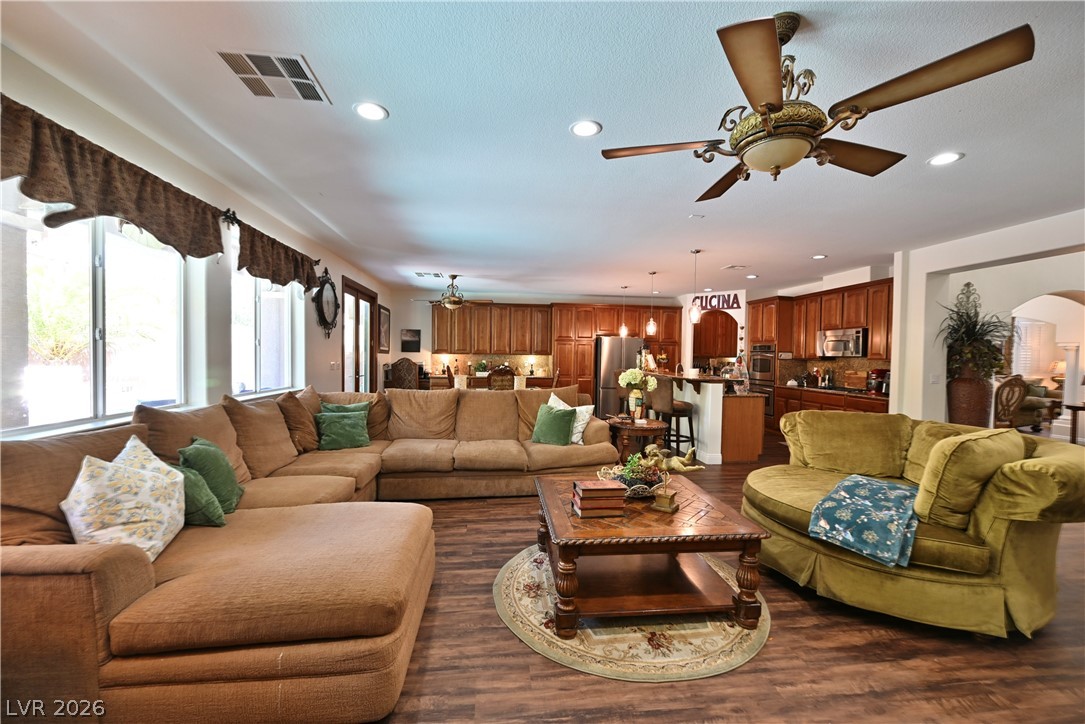 2729 Kildrummie Street Henderson, NV 89044 - Photo 19 of 42 An inviting open-concept living area boasts rich hardwood floors and abundant natural light, seamlessly flowing into a well-appointed kitchen.