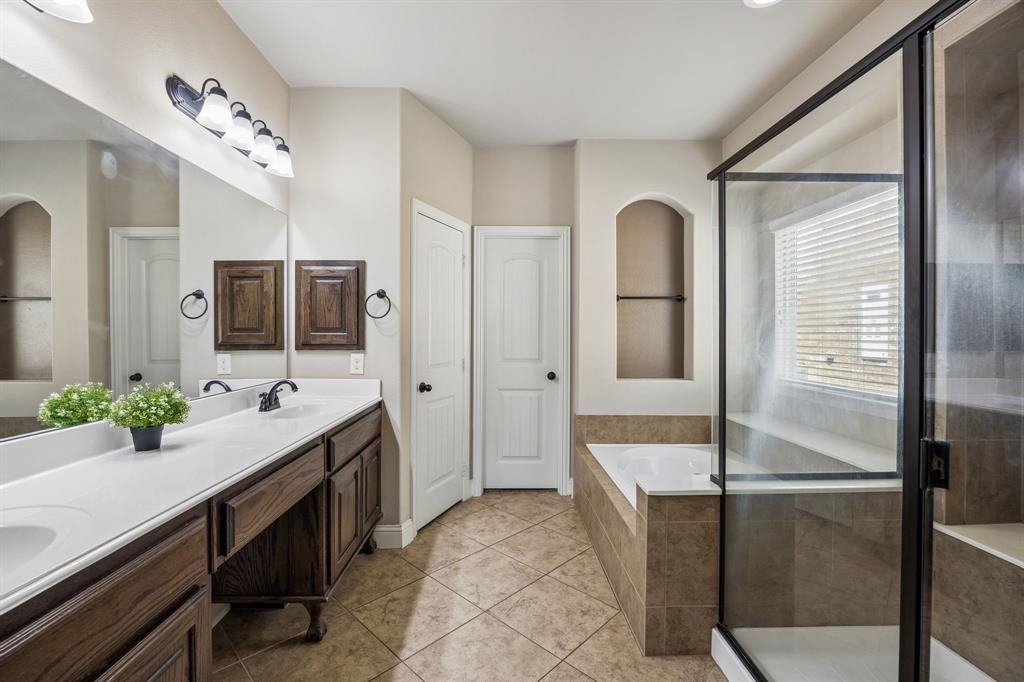 1014 Dunhill Lane Forney, TX 75126 - Photo 15 of 38 Primary bathroom with seperate soaking tub and shower with seat. Also two seperate sinks with a seating area in the middle.